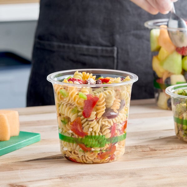 A clear 24 oz. compostable deli container filled with pasta salad.