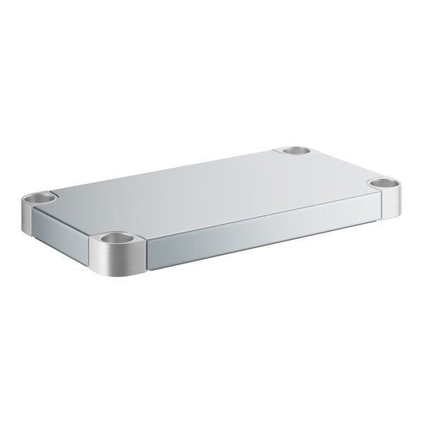 A silver metal rectangular shelf with metal corners under a white rectangular table.