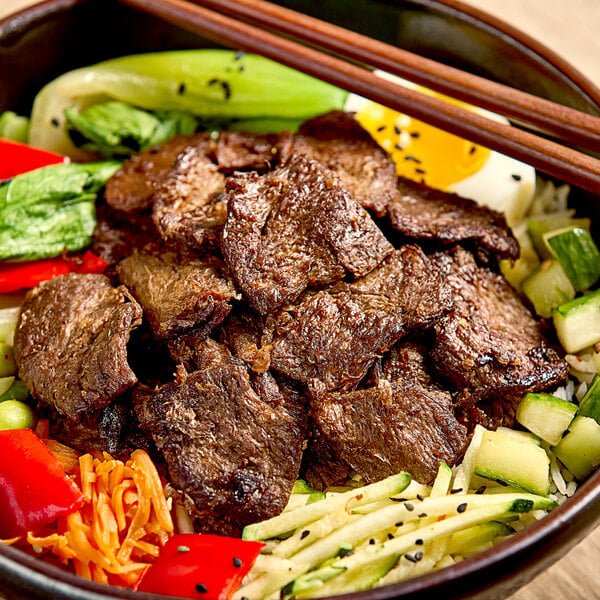 A bowl of unMEAT vegan steak strips with vegetables.