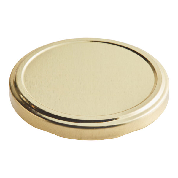 A close up of a gold metal lid with a plastisol liner.