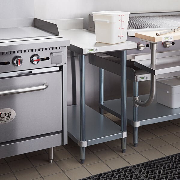 A Regency adjustable galvanized steel undershelf under a stainless steel work table.