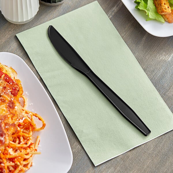 A napkin with a Choice black plastic knife on it.