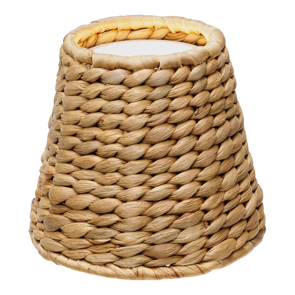 A Zafferano America water hyacinth woven lampshade with a white cover over a Poldina lamp.