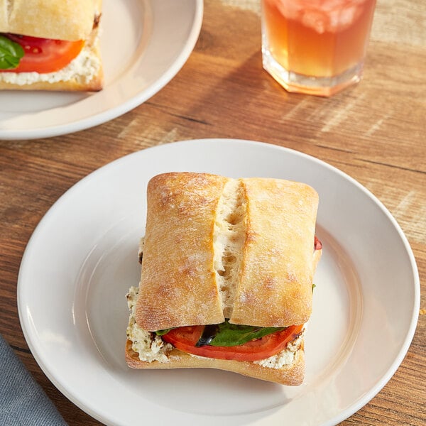 A Bridor sourdough ciabatta sandwich with tomato and cheese on a plate.