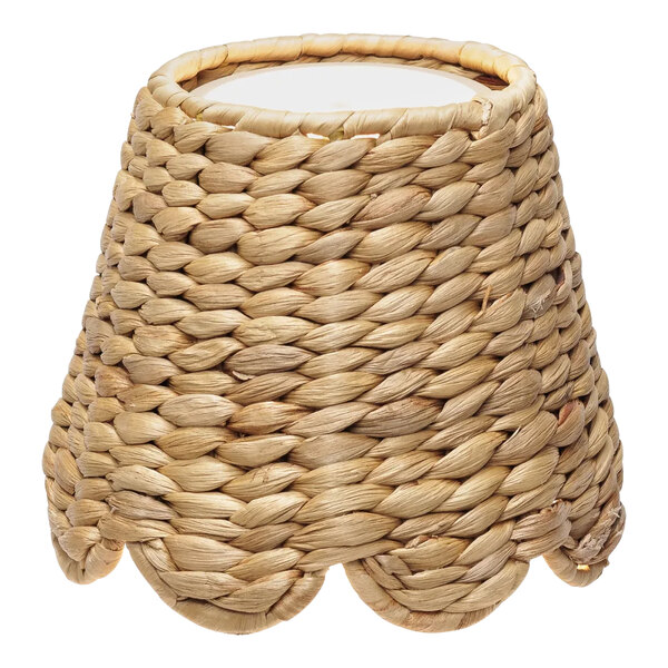 A Zafferano America woven water hyacinth lampshade on a Poldina lamp with a white background.