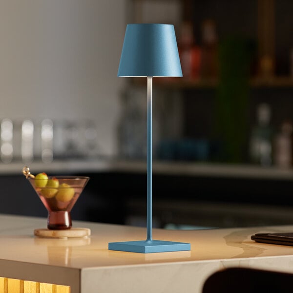 A Zafferano America Poldina Pro blue table lamp on a counter.