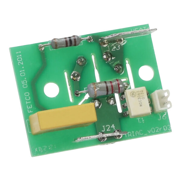 A green circuit board with yellow and white components, including a white rectangular object and a yellow and white resistor.