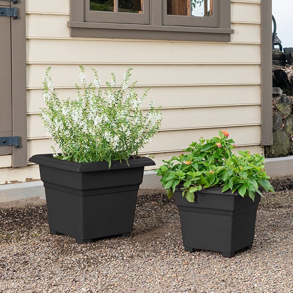 Two Novelty Manufacturing Co. black square tub planters on an outdoor patio table.