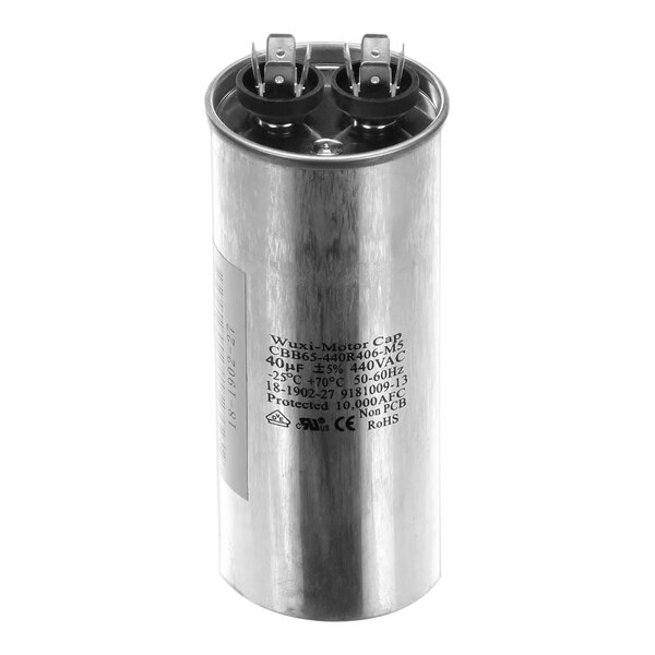 A round metal Ice-O-Matic capacitor with black and white text on it.