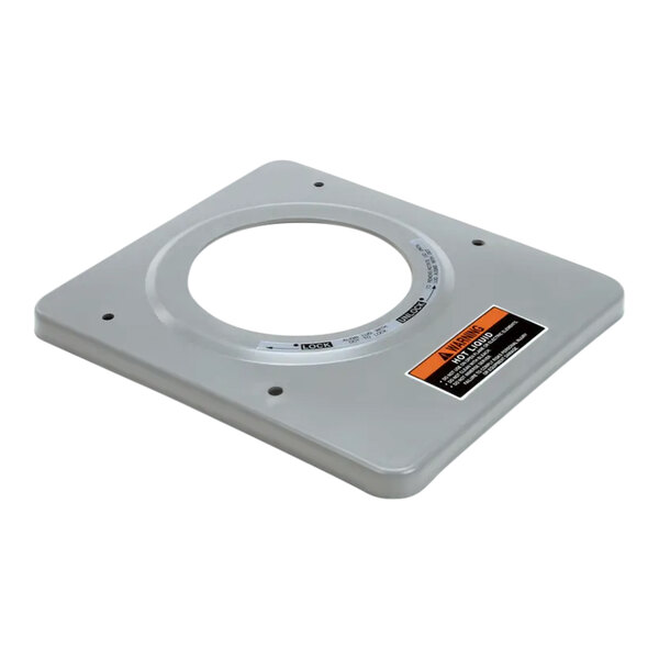 A gray metal square with a circle and orange decals.