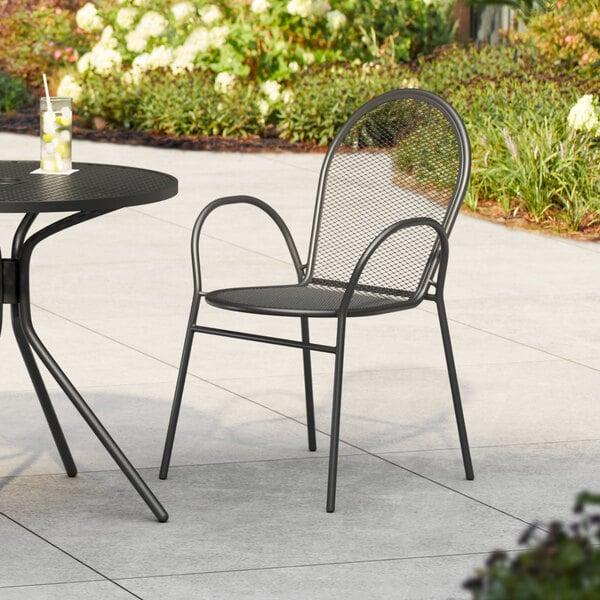 A black steel mesh arm chair on a patio.