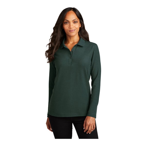 A woman wearing a dark green Port Authority long sleeve polo shirt.