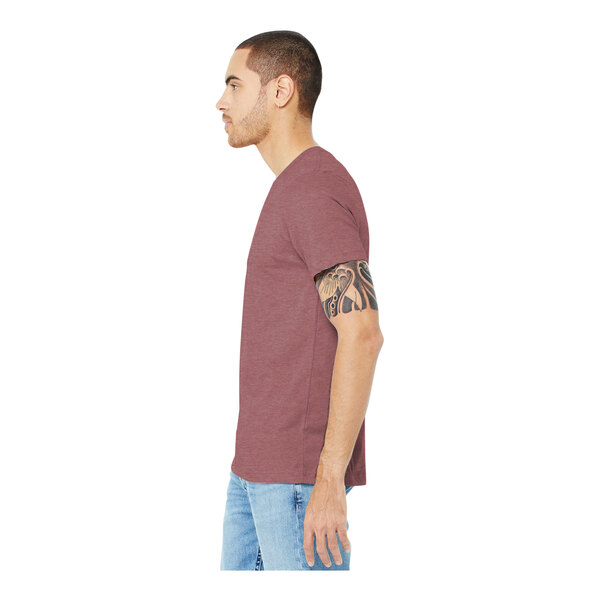 A man wearing a Bella + Canvas heather mauve short sleeve T-shirt with tattoos on his arm.