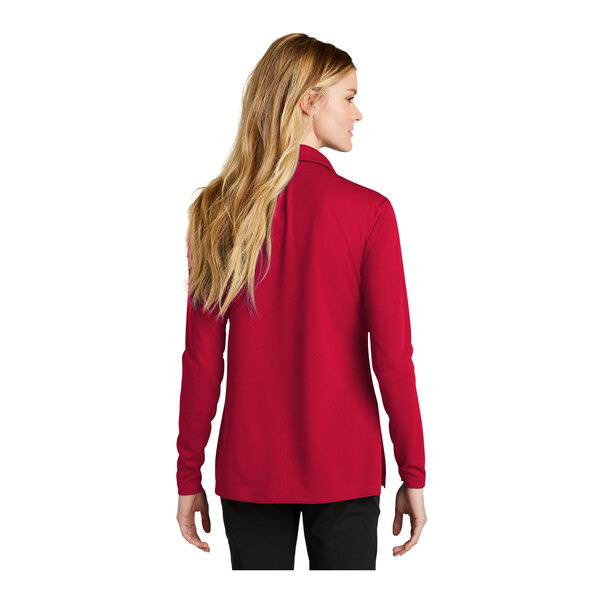 A woman wearing a red Nike long sleeve polo.