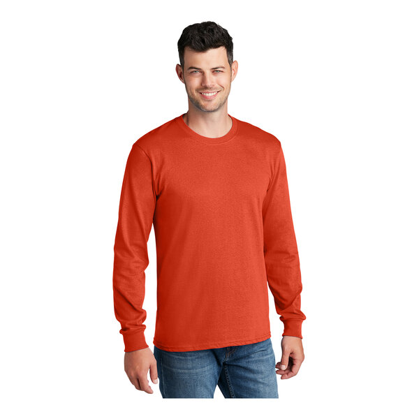 A man wearing an orange Port & Company long sleeve t-shirt.