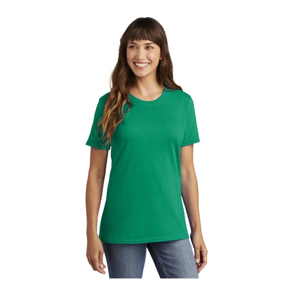 A woman wearing a green Port & Company T-shirt with a pocket.