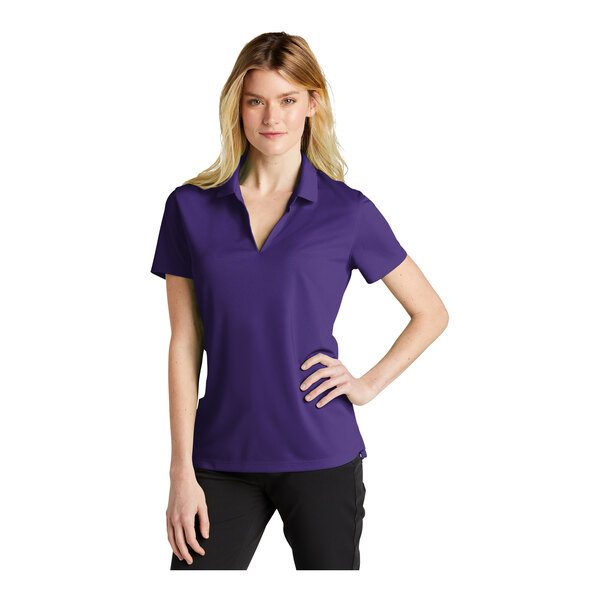 A woman wearing a purple Nike polo shirt.