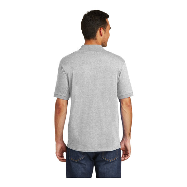 A man wearing a grey Port & Company polo shirt with a pocket.