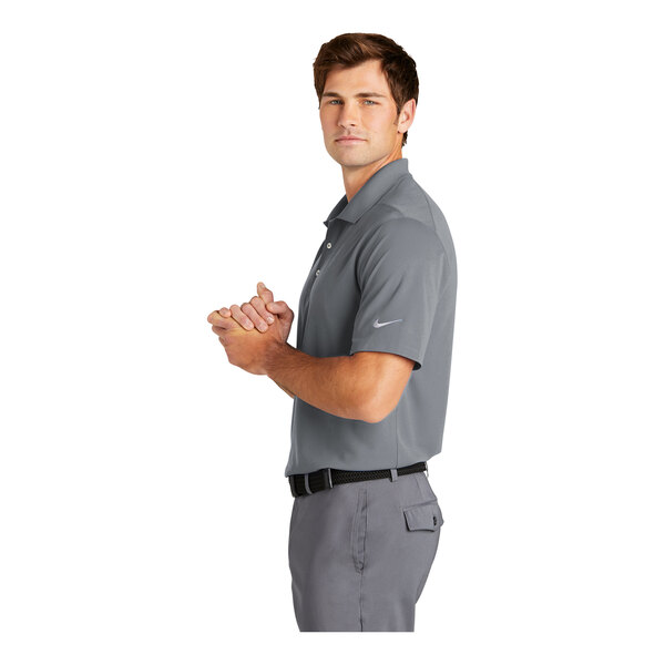 A man wearing a cool grey Nike Dri-Fit polo shirt with a front pocket.