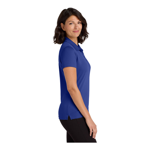 A woman wearing a blue Port Authority polo shirt with black trim.