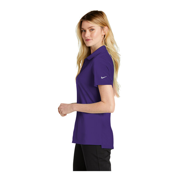 A woman wearing a purple Nike polo shirt with black trim.