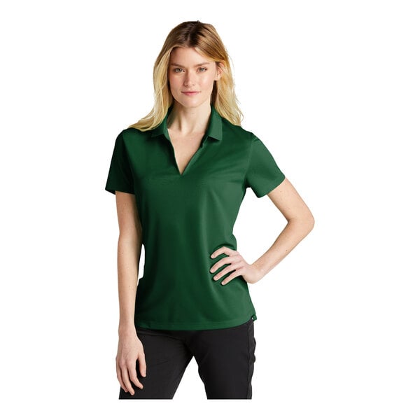 A woman wearing a green Nike polo shirt.