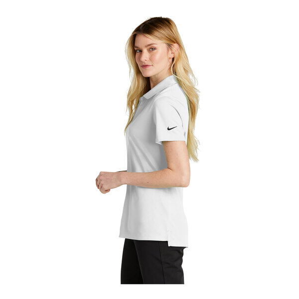 A woman wearing a white Nike short sleeve polo with black trim.