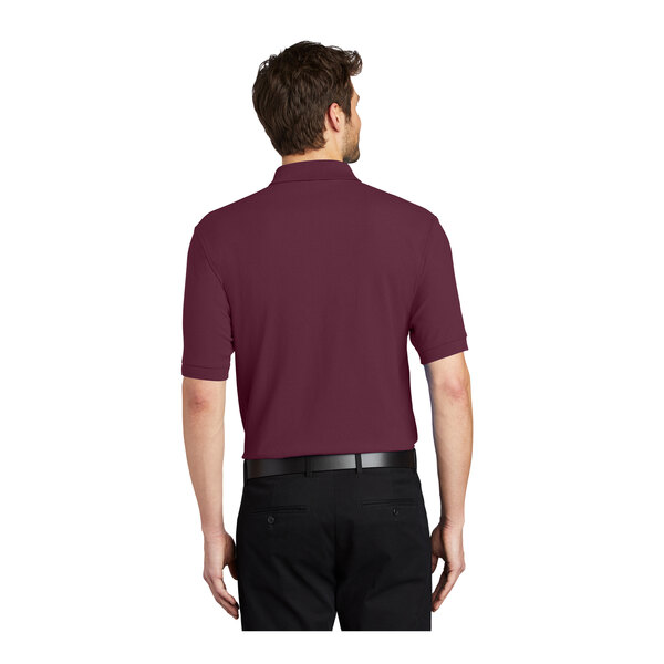 A man wearing a maroon Port Authority® polo shirt.