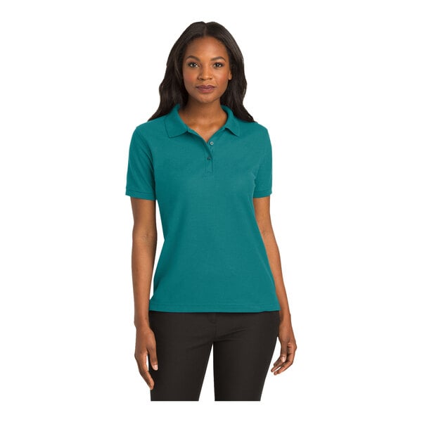 A woman wearing a teal green Port Authority polo shirt.