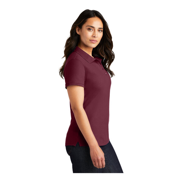 A woman wearing a burgundy Port Authority polo shirt.