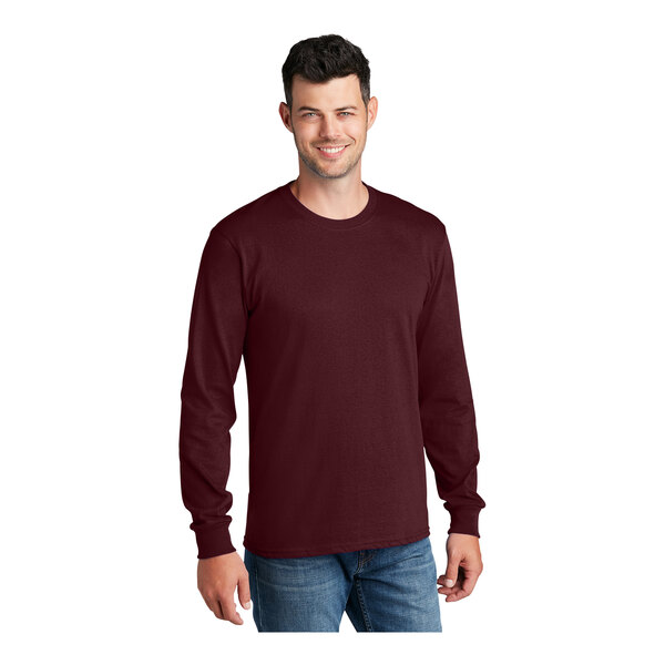 A man wearing a Port & Company athletic maroon long sleeve t-shirt.