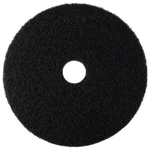 A black circular Scrubble stripping floor pad with a hole in the middle.