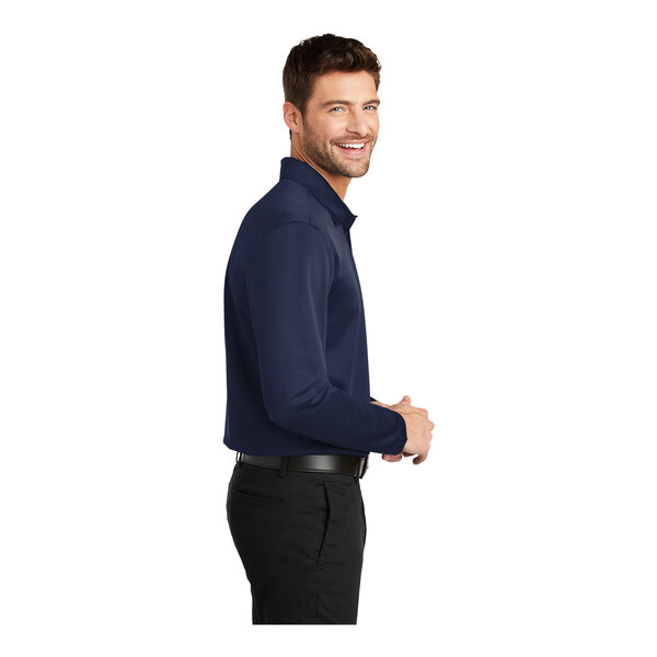 A man wearing a navy Port Authority® long sleeve polo shirt.