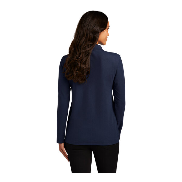 A woman with long brown hair wearing a navy Port Authority long sleeve polo shirt.