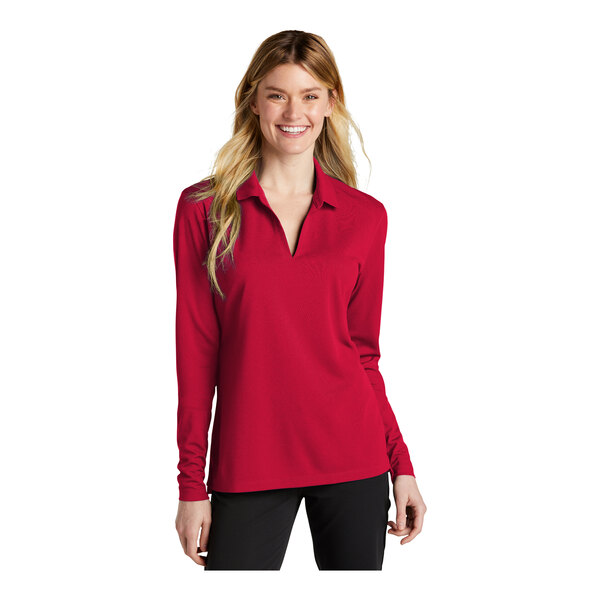 A woman wearing a red Nike long sleeve polo shirt.