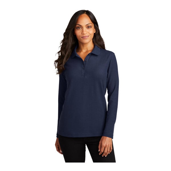 A woman wearing a navy Port Authority long sleeve polo shirt.