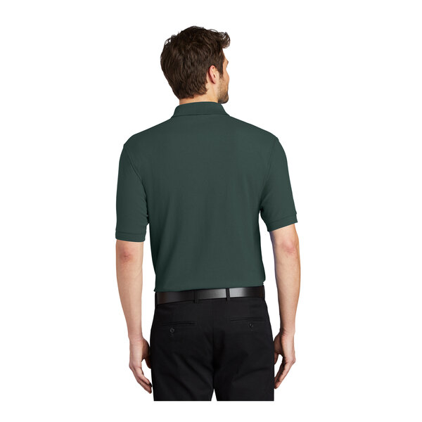 A man wearing a dark green Port Authority silk touch polo shirt.