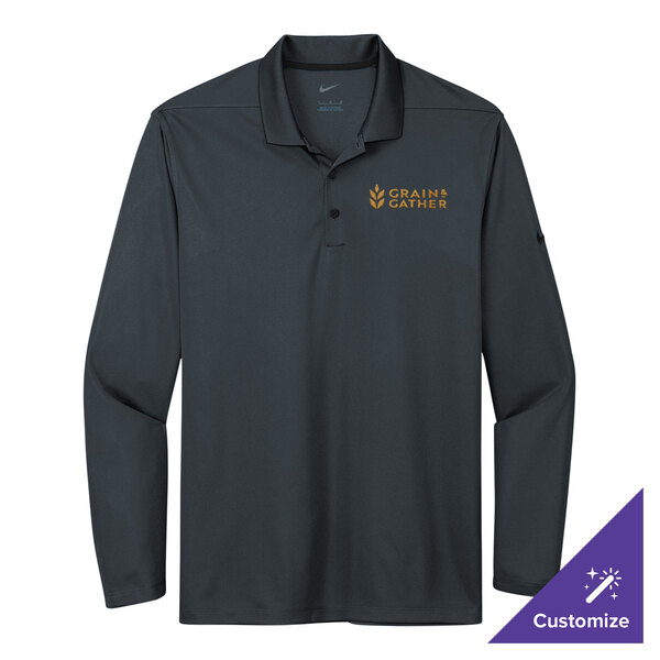 A Nike anthracite long sleeve polo shirt on a hanger. The shirt has gold embroidery.