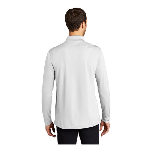 A man wearing a white Port Authority long sleeve polo shirt.
