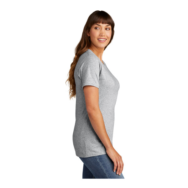 A woman wearing a grey Port & Company short sleeve t-shirt.