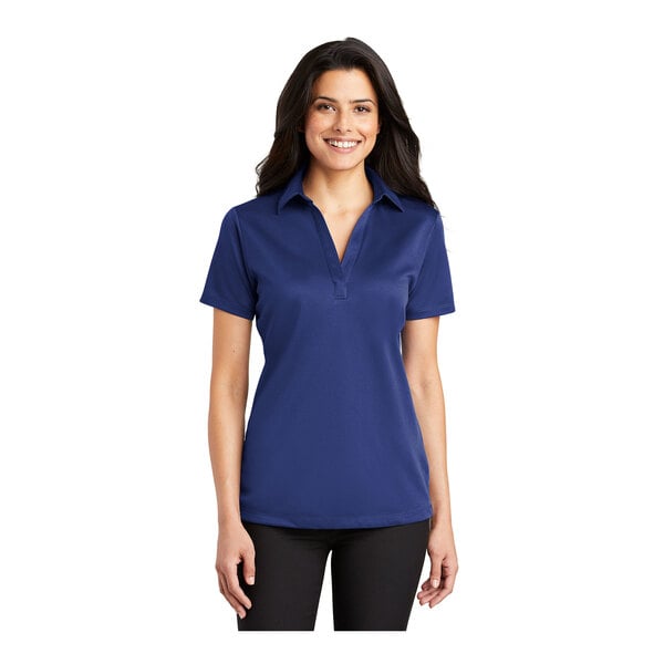 A woman wearing a Port Authority royal blue silk touch polo shirt.