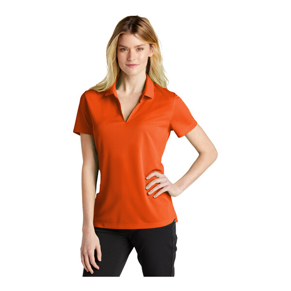 A woman wearing a brilliant orange Nike polo shirt.