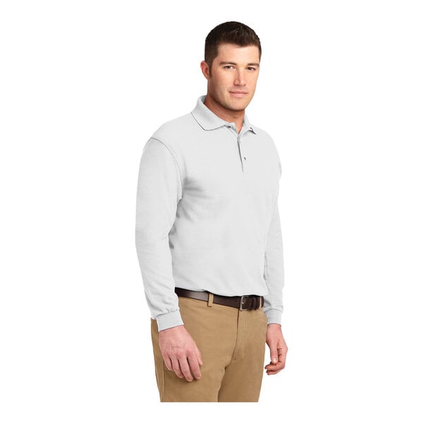 A man wearing a white Port Authority® long sleeve polo shirt.