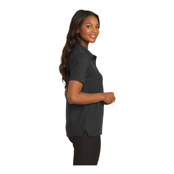 A woman wearing a black Port Authority short sleeve polo shirt.