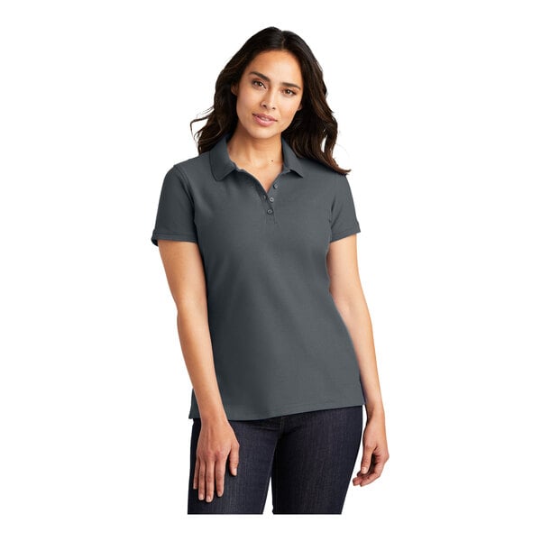 A woman wearing a graphite Port Authority short sleeve polo shirt.