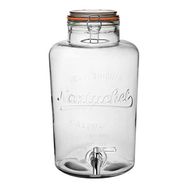 A clear glass jar with a spigot and a lid.