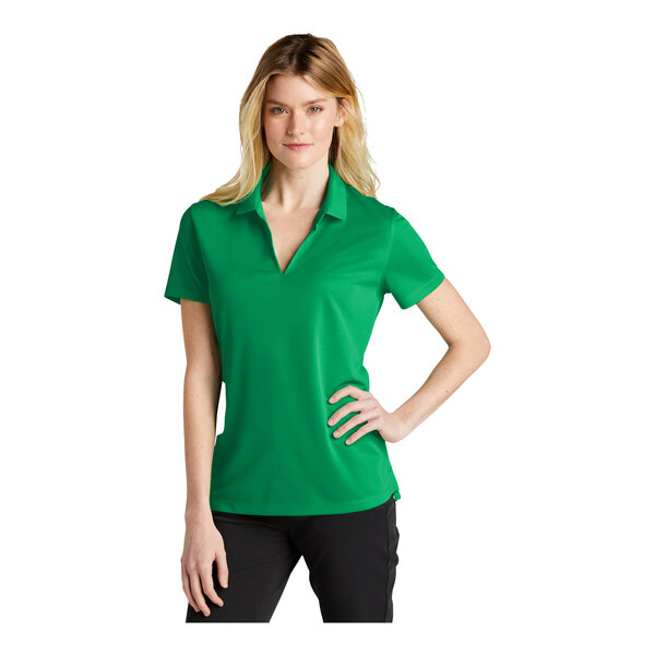 A woman wearing a green Nike polo shirt.