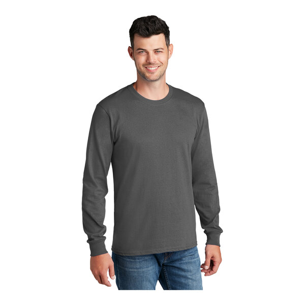 A man wearing a Port & Company long sleeve charcoal t-shirt.