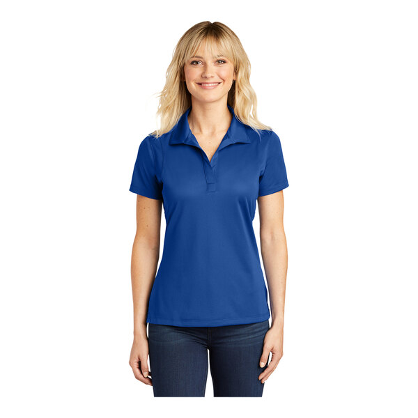 A woman wearing a blue Sport-Tek short sleeve polo shirt with a collar.