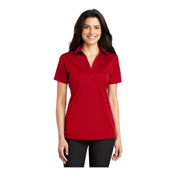 A woman wearing a red Port Authority silk touch polo shirt.